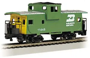 A green caboose is on the tracks.