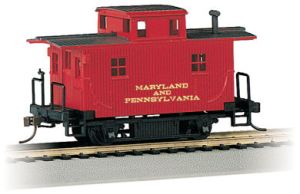 A red caboose is sitting on the tracks.