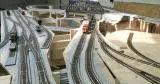 A train is going down the tracks in an indoor model.