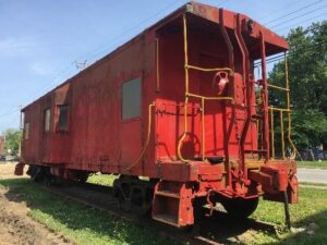 A red train car sitting on top of a track.