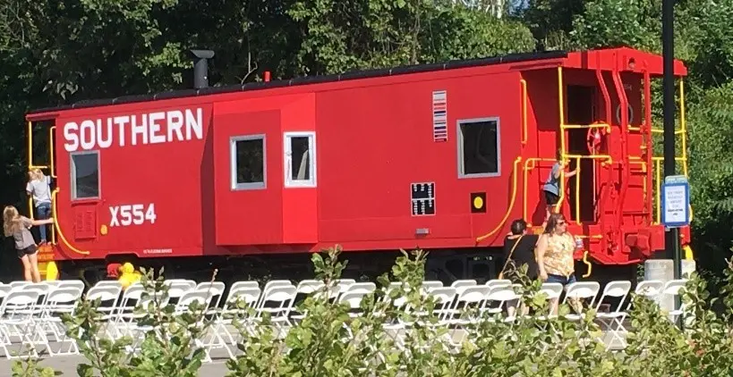 A red train car sitting on top of a track.