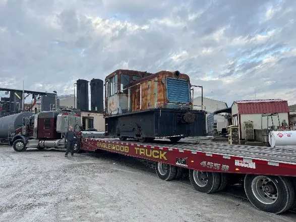 A train car is being loaded onto the trailer.