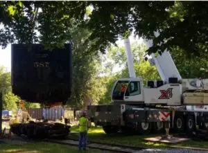 A crane is being lifted by a truck.
