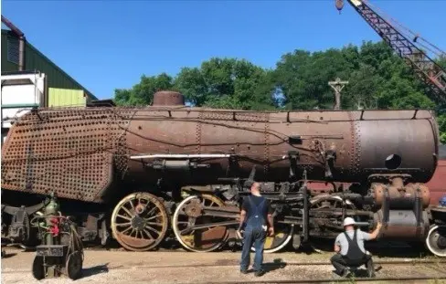 A train is being worked on by some people.