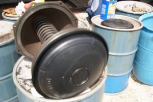 A close up of an open drum with other barrels