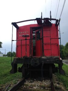 A red train car sitting in the grass.