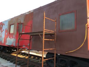A red train car with scaffolding around it.